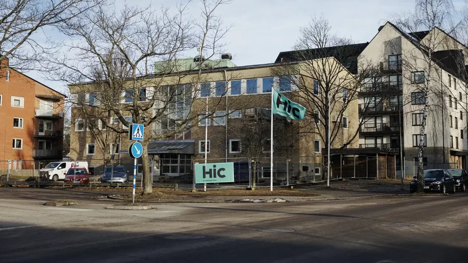 En gul tegelbyggnad med byggstängsel runt.